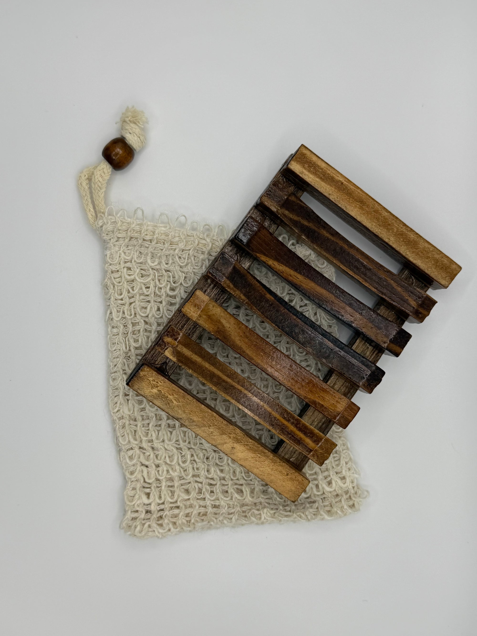 Wooden soap dish on a textured beige bag with a white background
