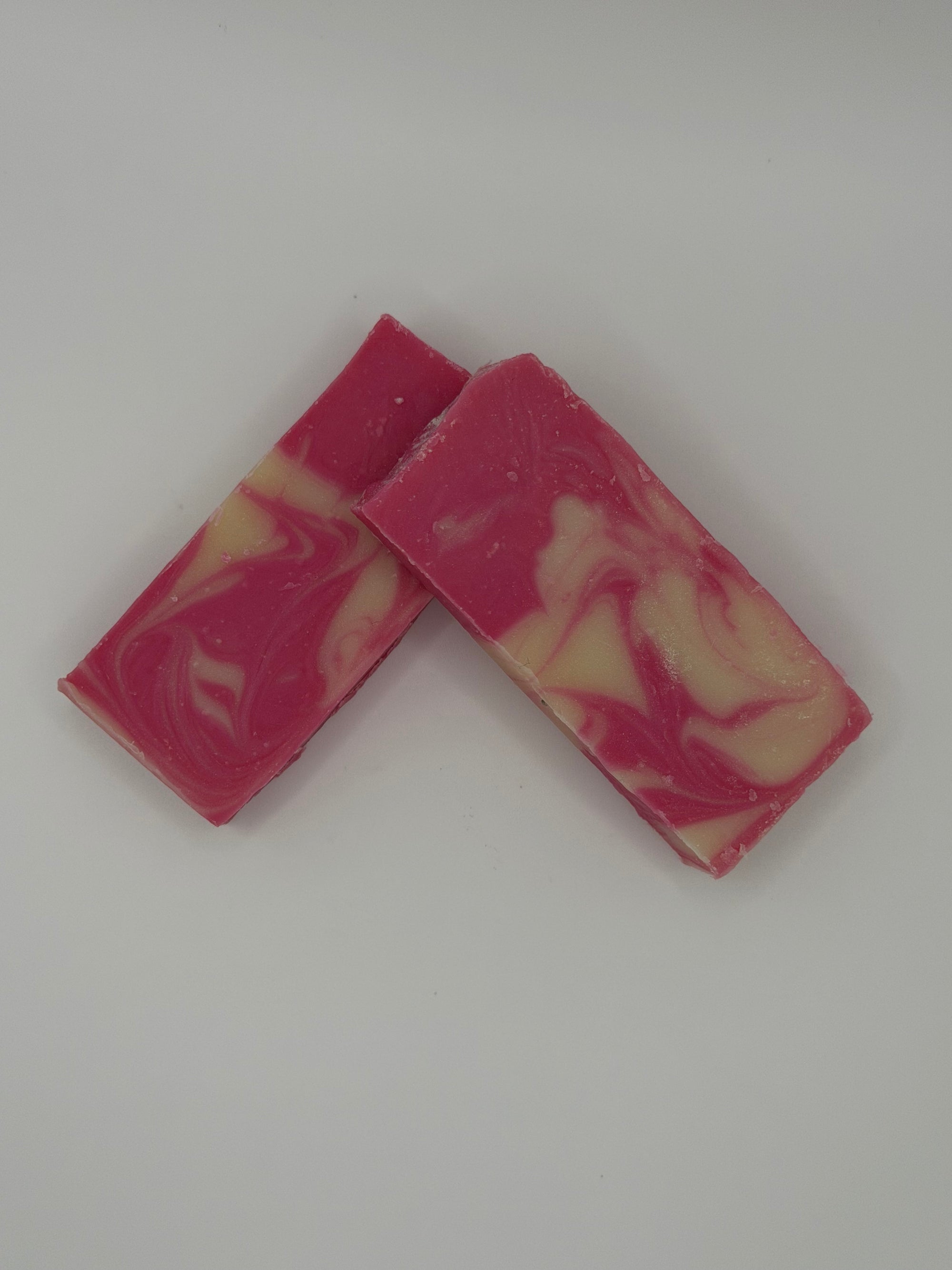 Two pink and white marbled soap bars on a white background