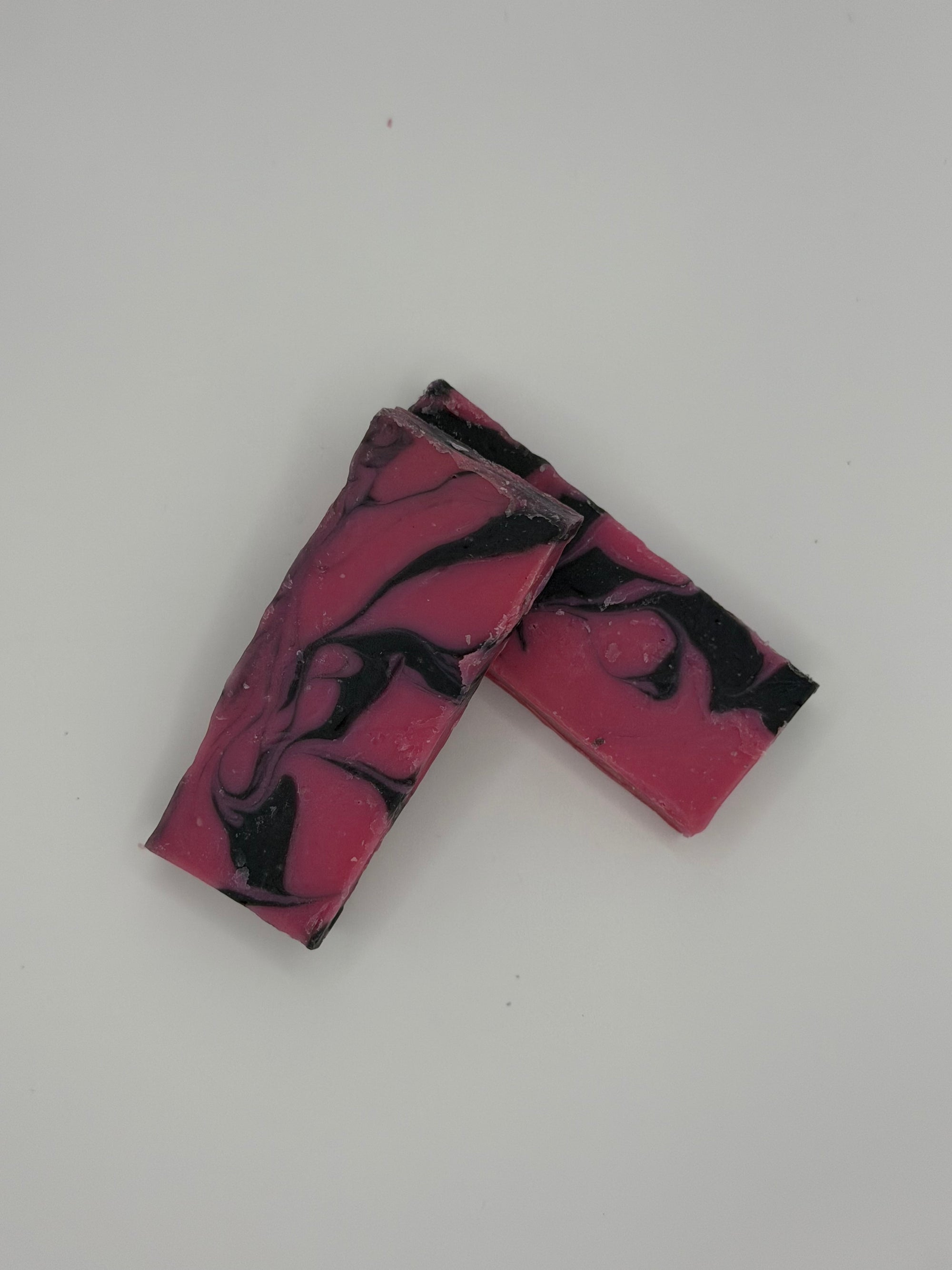 Marbled pink and black rectangular soap on a light gray background