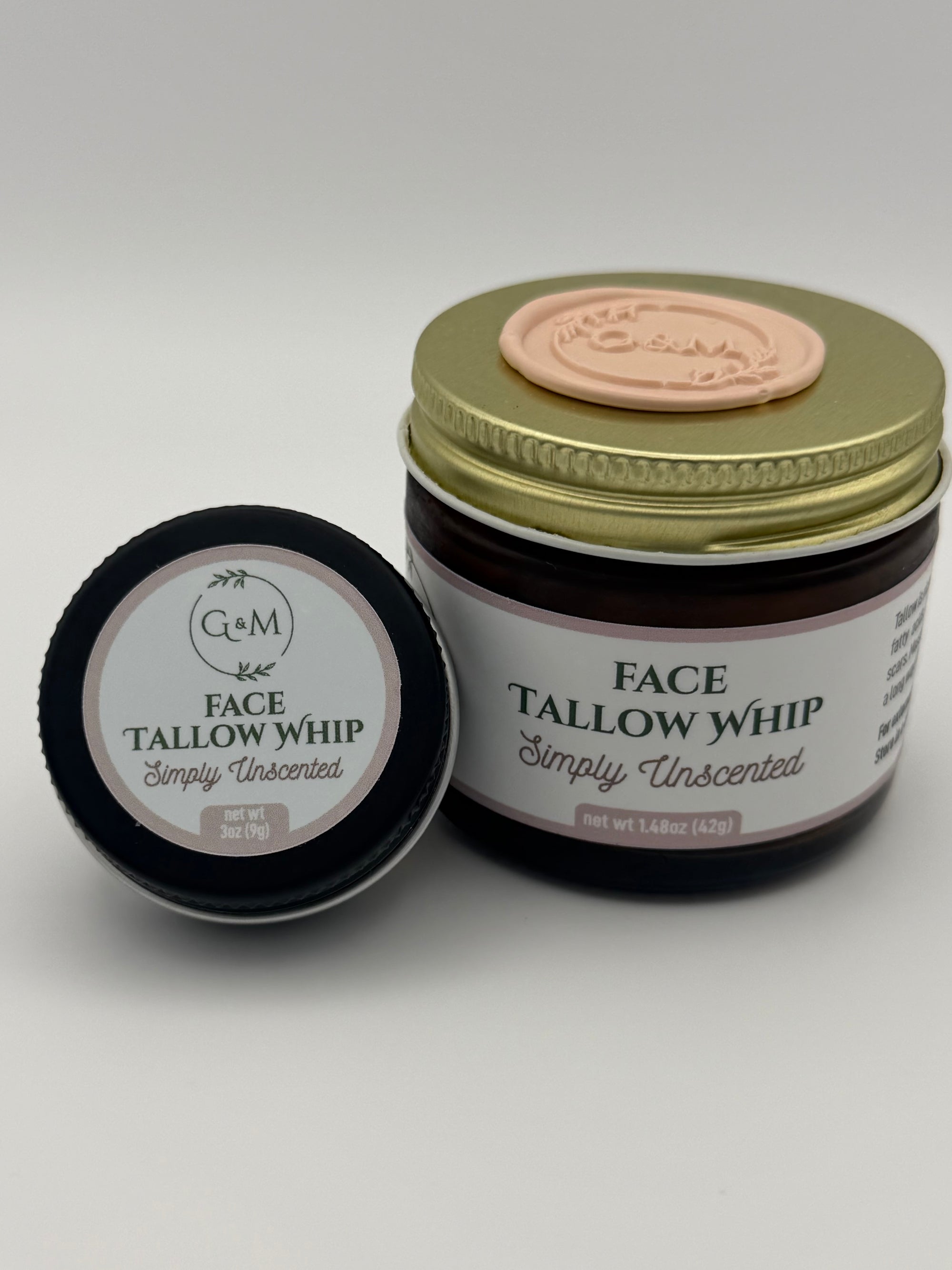 Lavender Face Tallow Whip jar with gold lid and beige wax seal on it and black travel tin on a white background